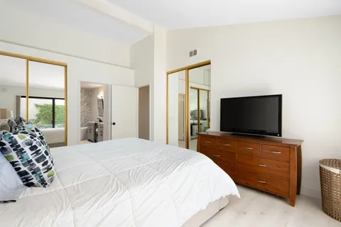 a bedroom with a bed and a flat screen tv