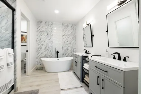 a bathroom with a bathtub sink mirror and toilet