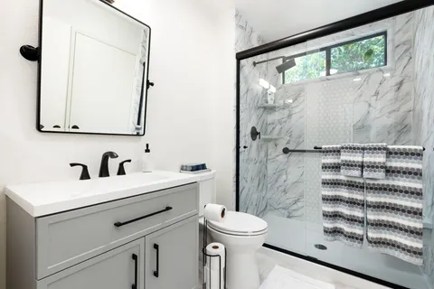 a bathroom with a sink a toilet and a mirror