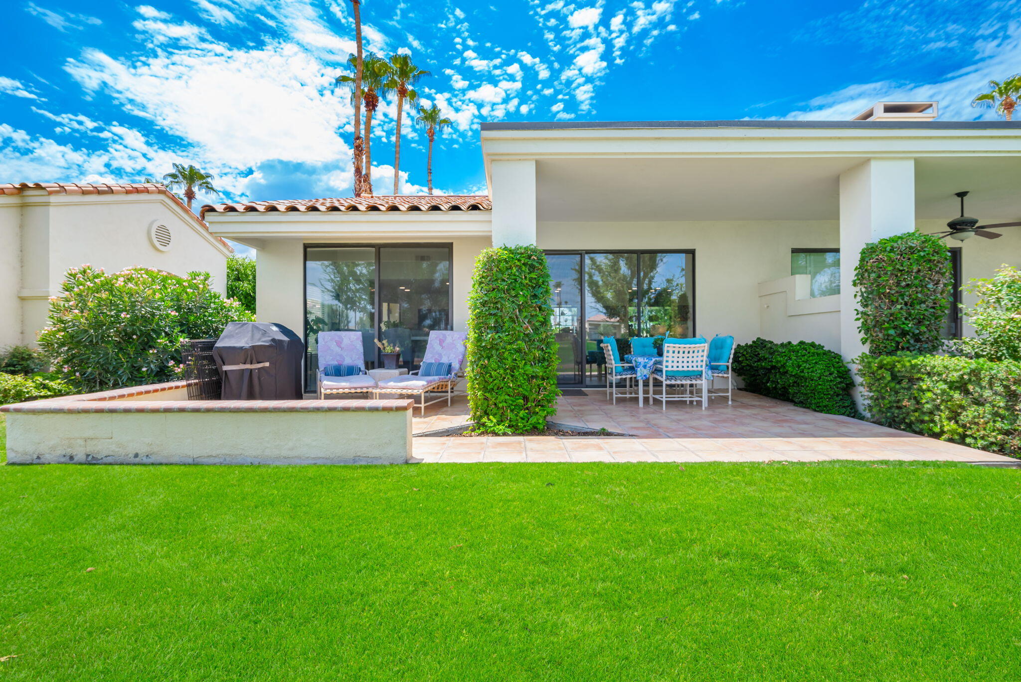 54912 Shoal Creek La Quinta, CA 92253 - Photo 32 of 36 a view of a patio with table and chairs potted plants and a large tree