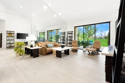 a living room with furniture and floor to ceiling window