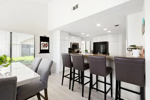 a view of a dining room with furniture and a kitchen