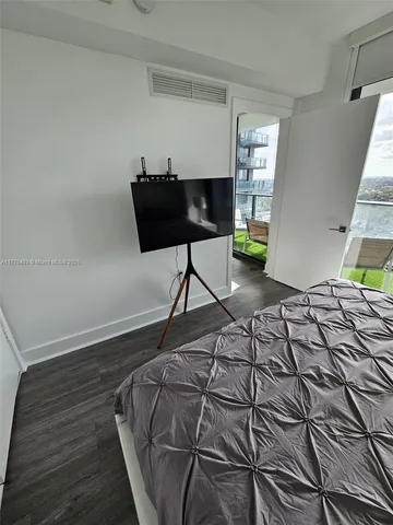 a bedroom with a bed and a flat screen tv