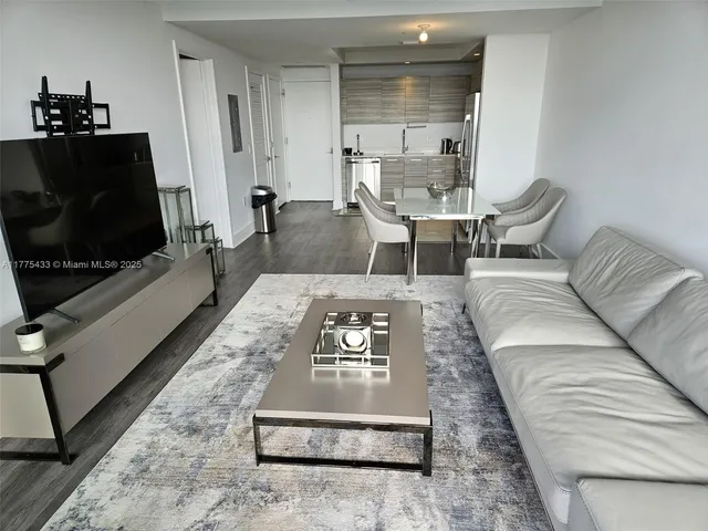 a living room with furniture and a floor to ceiling window
