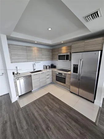 a kitchen with wooden floors and stainless steel appliances