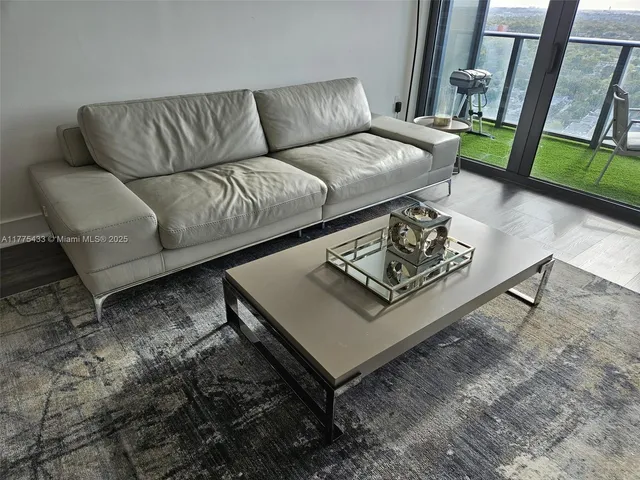 a living room with furniture rug and a large window
