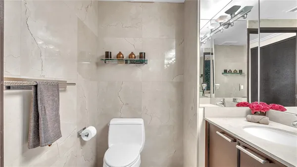 a bathroom with a sink vanity granite toilet and shower
