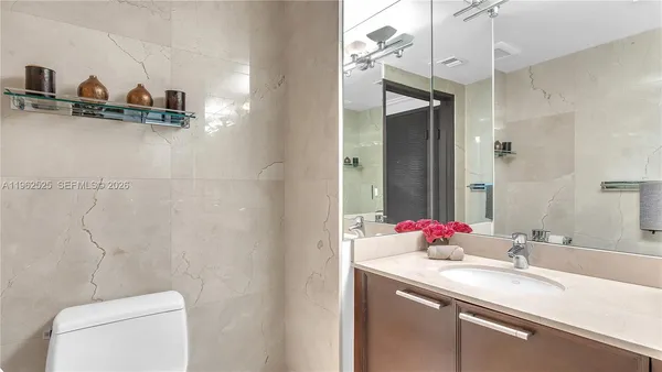 a bathroom with a sink and a mirror with toilet