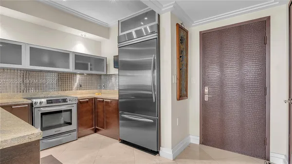 a kitchen with stainless steel appliances granite countertop a refrigerator and a stove