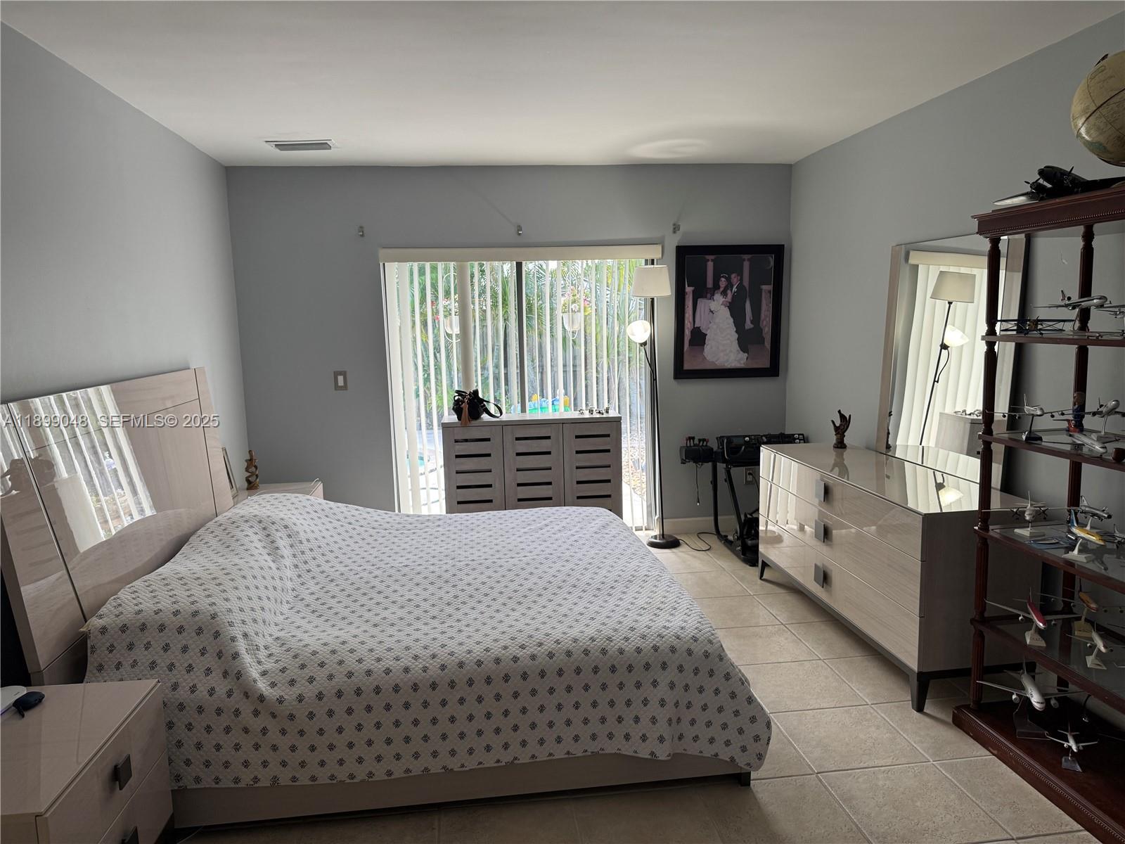 14700 Southwest 151st Terrace Miami, FL 33196 - Photo 14 of 19 a bedroom with a bed and a large window