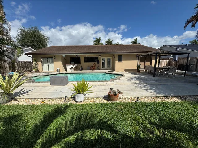 a view of a house with a big yard and potted plants
