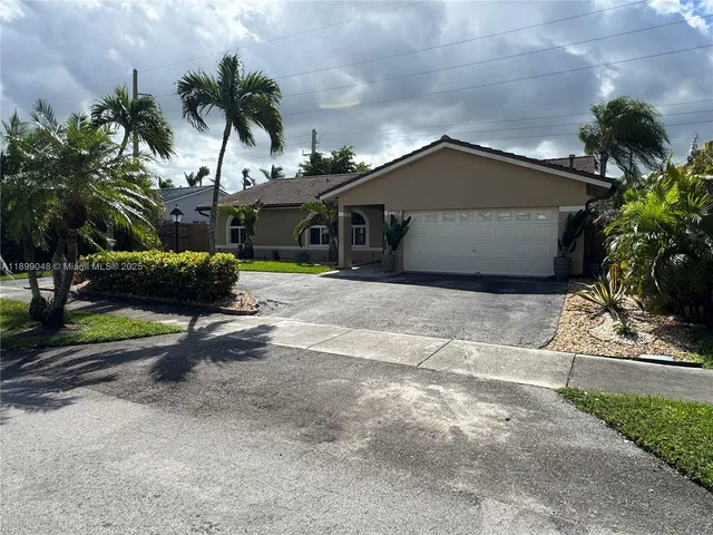 a view of a house with a yard and potted plants