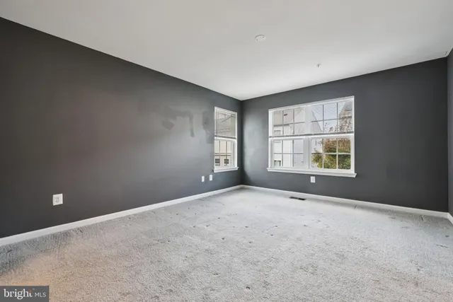 an empty room with windows and closet
