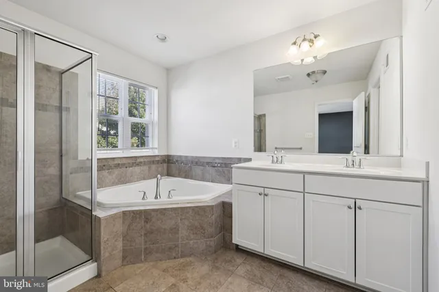 a bathroom with a tub a sink and mirror