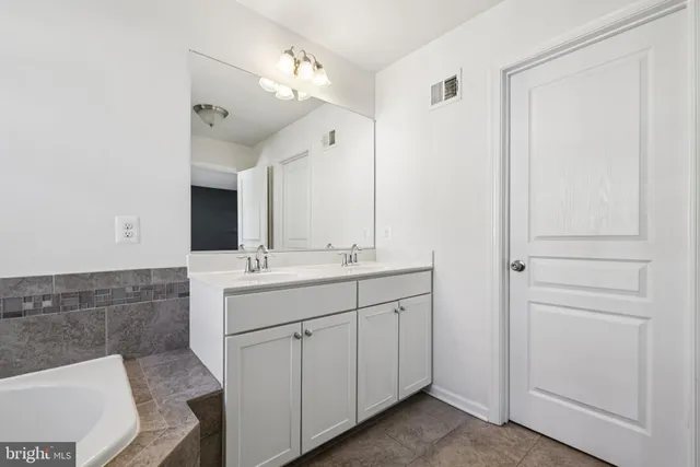 a bathroom with a double vanity sink mirror and
