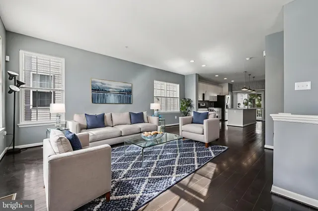 a living room with furniture wooden floor and a large window