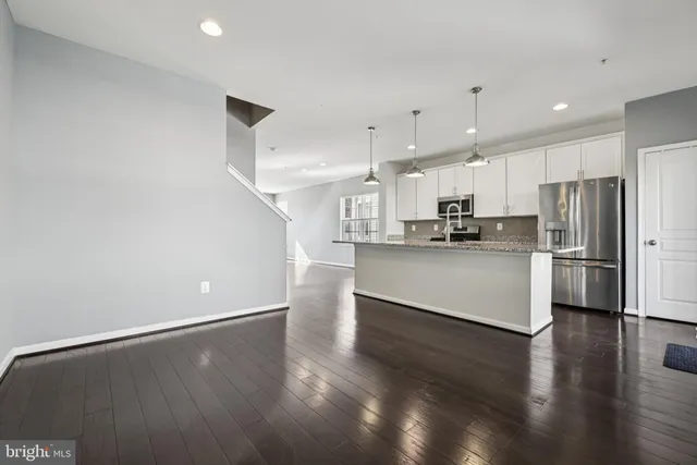 a kitchen with stainless steel appliances a refrigerator and wooden floor