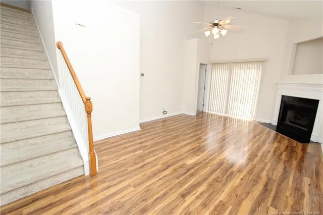 a view of a room with wooden floor and ceiling fan