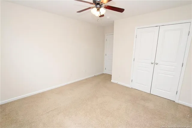 an empty room with a ceiling fan and a window