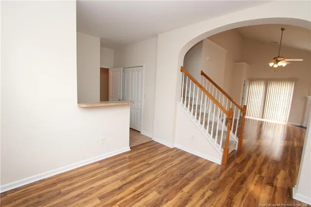 a view of a hallway with wooden floor and staircase