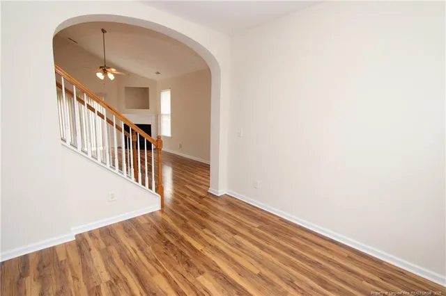 a view of a hallway with wooden floor and staircase