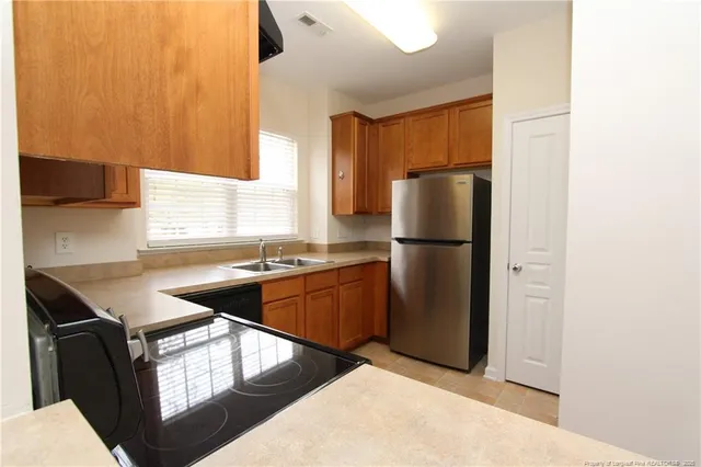 a kitchen with stainless steel appliances granite countertop a refrigerator and a sink
