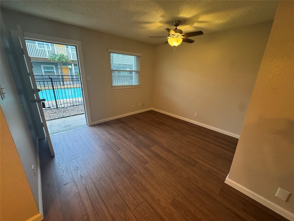 2401 Manor Road, Unit 118 Austin, TX 78722 - Photo 2 of 8 a view of a room with wooden floor and a ceiling fan
