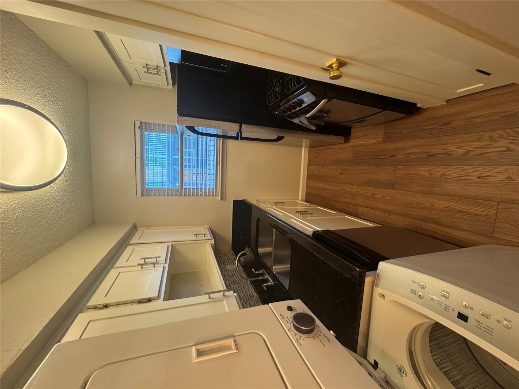 2401 Manor Road, Unit 118 Austin, TX 78722 - Photo 4 of 8 a kitchen with a sink and wooden floor