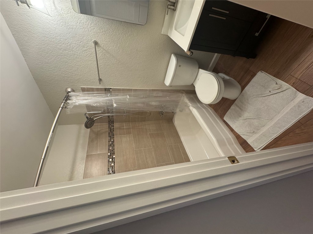 2401 Manor Road, Unit 118 Austin, TX 78722 - Photo 5 of 8 a bathroom with a toilet and a shower