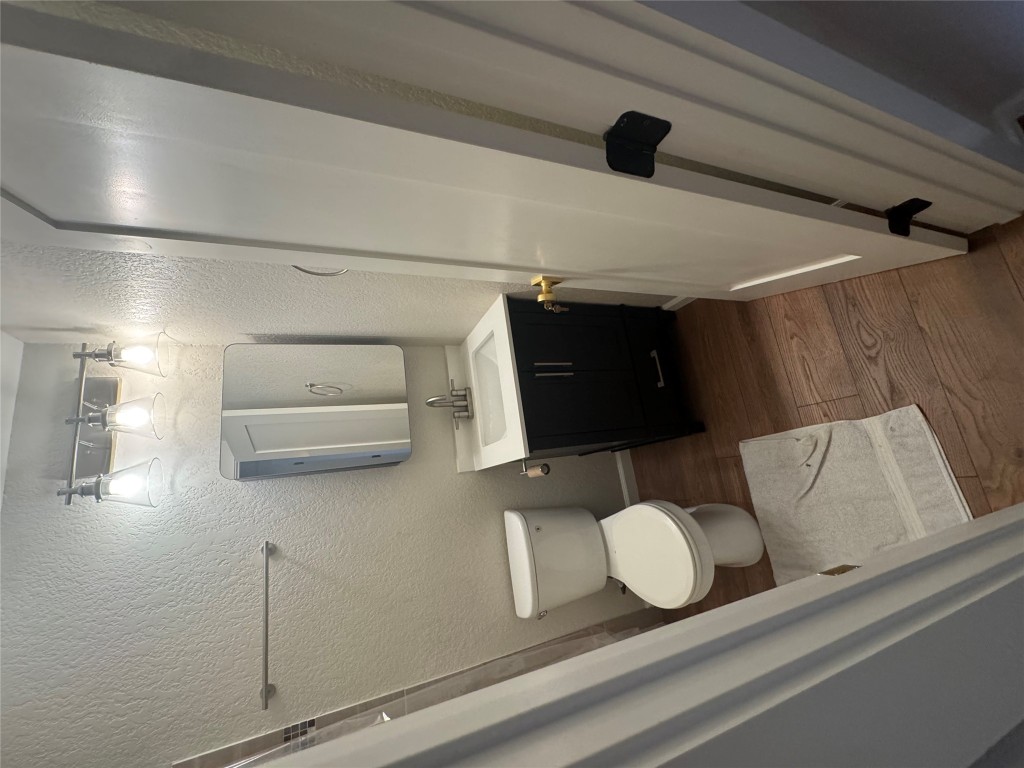 2401 Manor Road, Unit 118 Austin, TX 78722 - Photo 6 of 8 a bathroom with a toilet sink and mirror