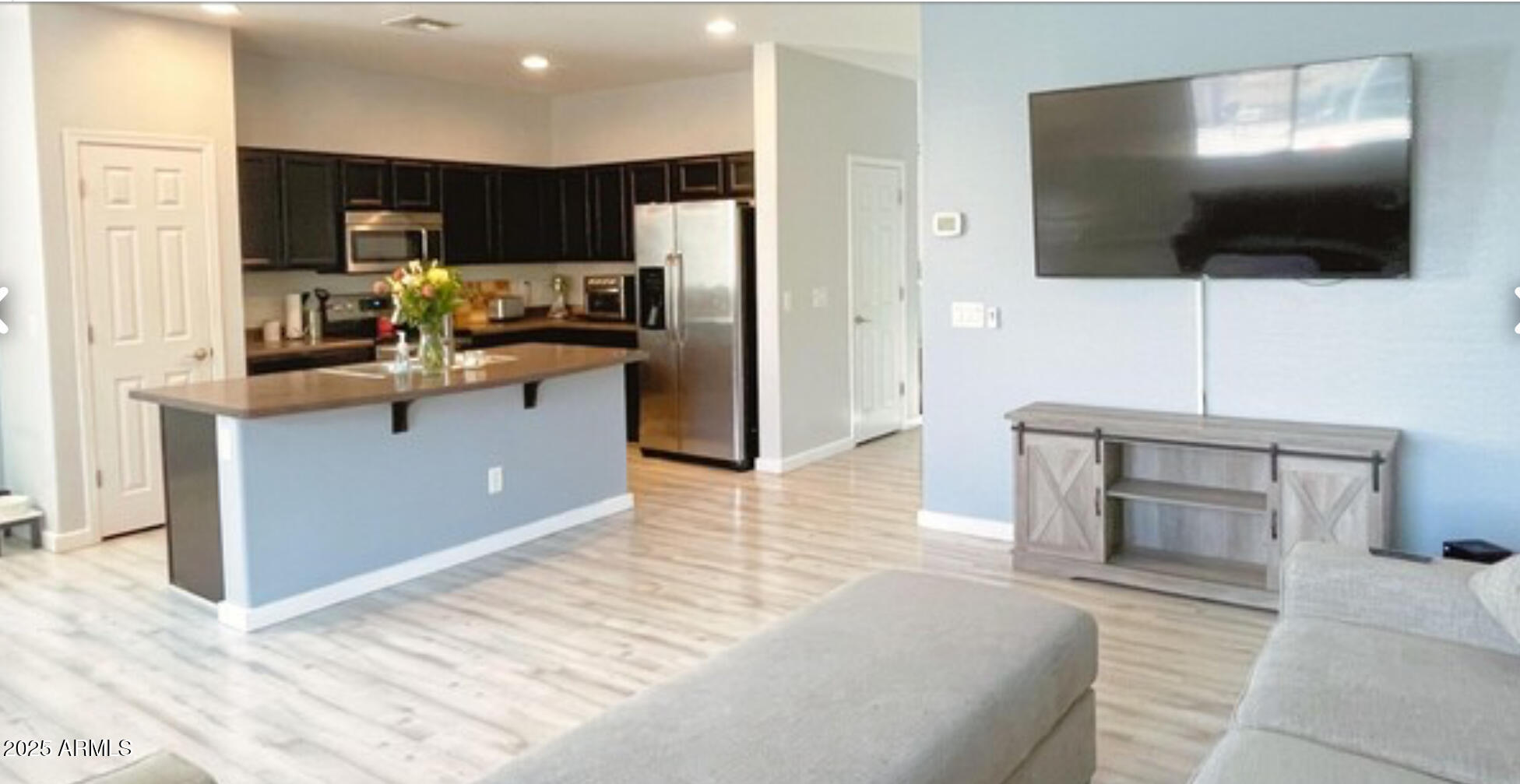 2542 West Gaby Road Phoenix, AZ 85041 - Photo 6 of 12 a living room with stainless steel appliances furniture a flat screen tv and kitchen view