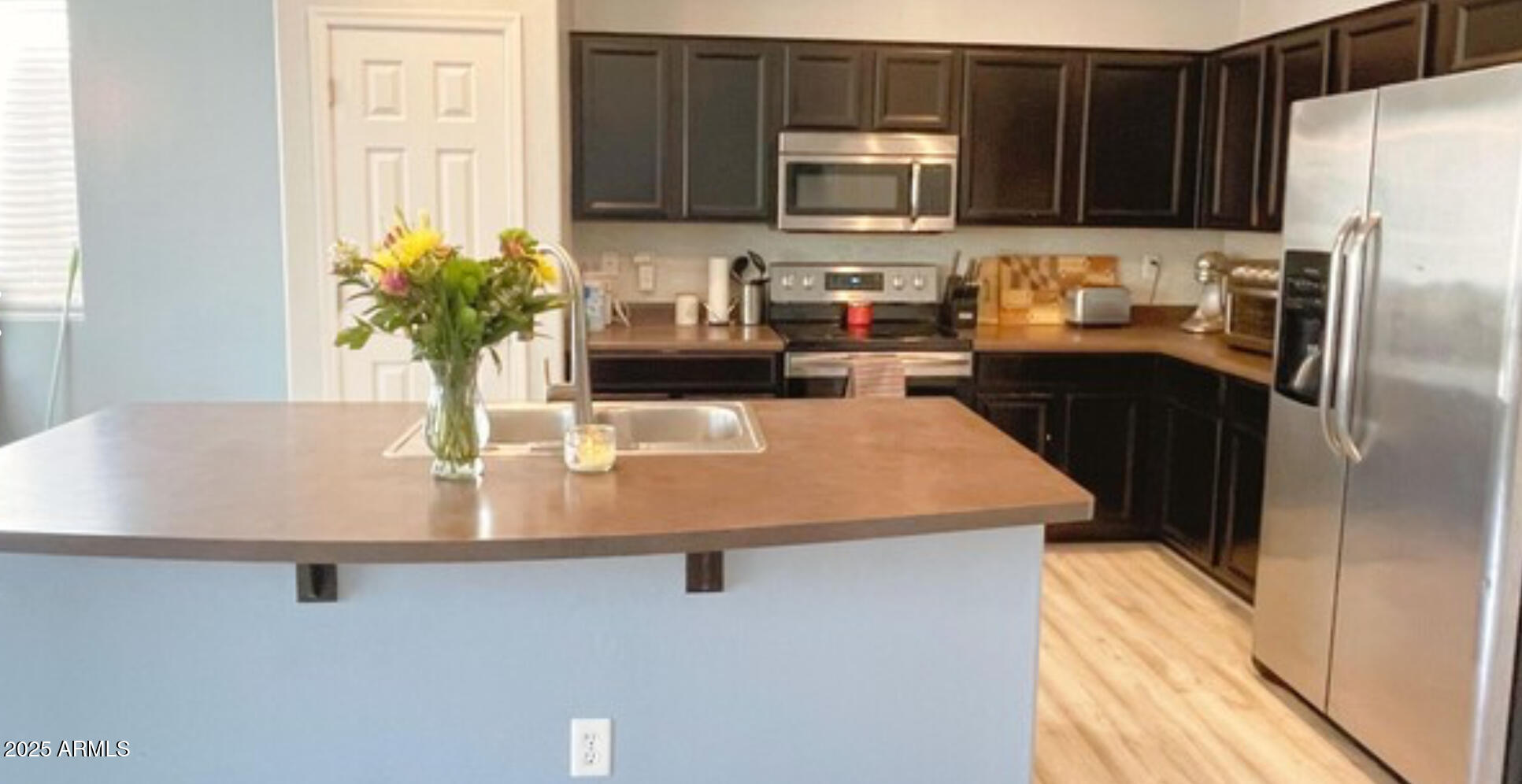 2542 West Gaby Road Phoenix, AZ 85041 - Photo 7 of 12 a kitchen with stainless steel appliances a sink a microwave a refrigerator and cabinets
