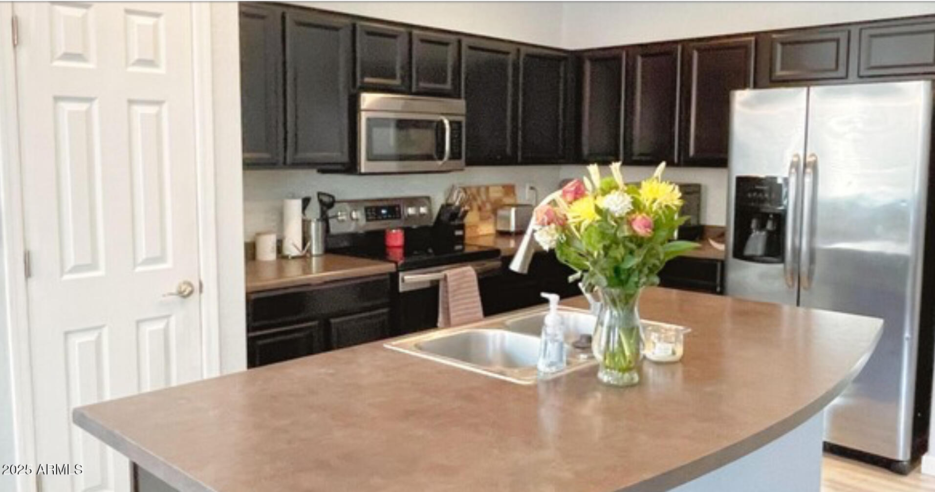 2542 West Gaby Road Phoenix, AZ 85041 - Photo 8 of 12 a kitchen with stainless steel appliances granite countertop a refrigerator a stove a microwave a sink