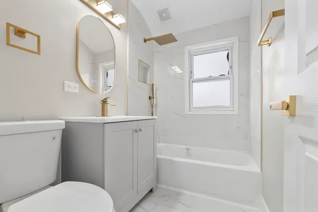 a bathroom with a toilet a sink a mirror and a bathtub