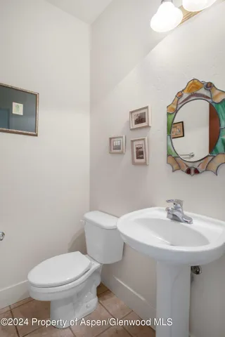 a bathroom with a toilet a sink and mirror