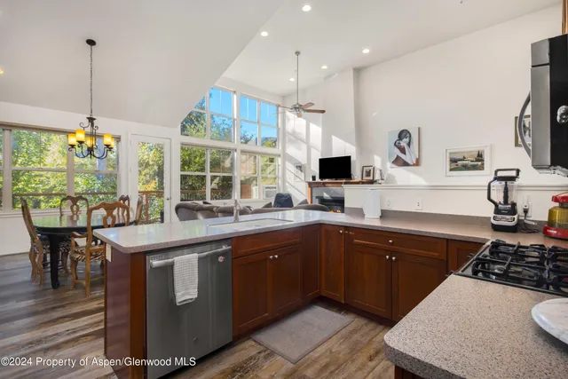 a kitchen with kitchen island granite countertop a sink and a stove