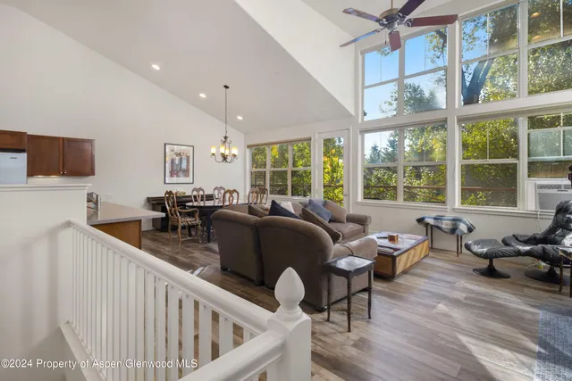 a living room with furniture and floor to ceiling windows