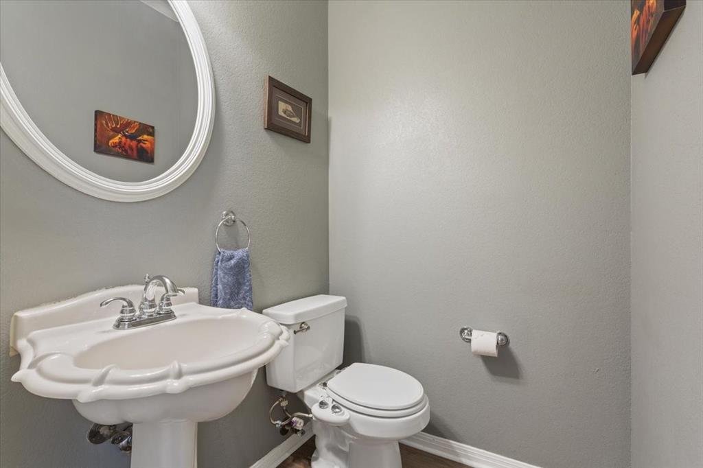 111 Spring Creek Street Waco, TX 76705 - Photo 29 of 40 Pedestal sink with chrome-finish faucet, oval mirror, and a white toilet
