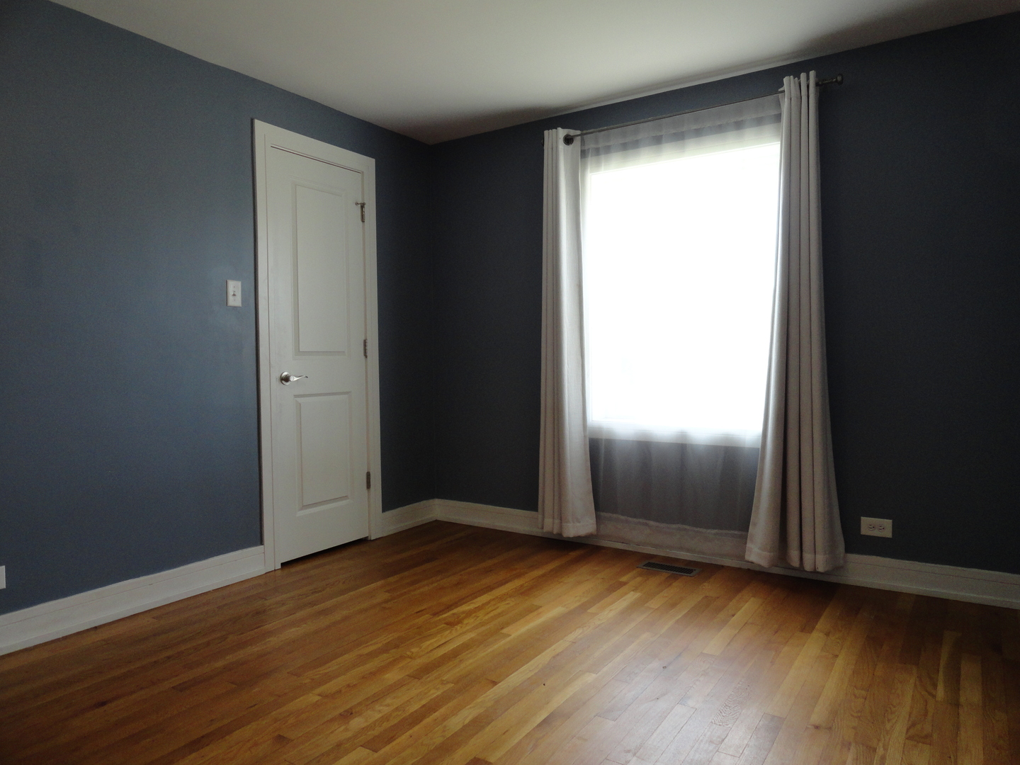 1410 Maple Avenue, Unit 1 Berwyn, IL 60402 - Photo 7 of 15 an empty room with wooden floor and windows