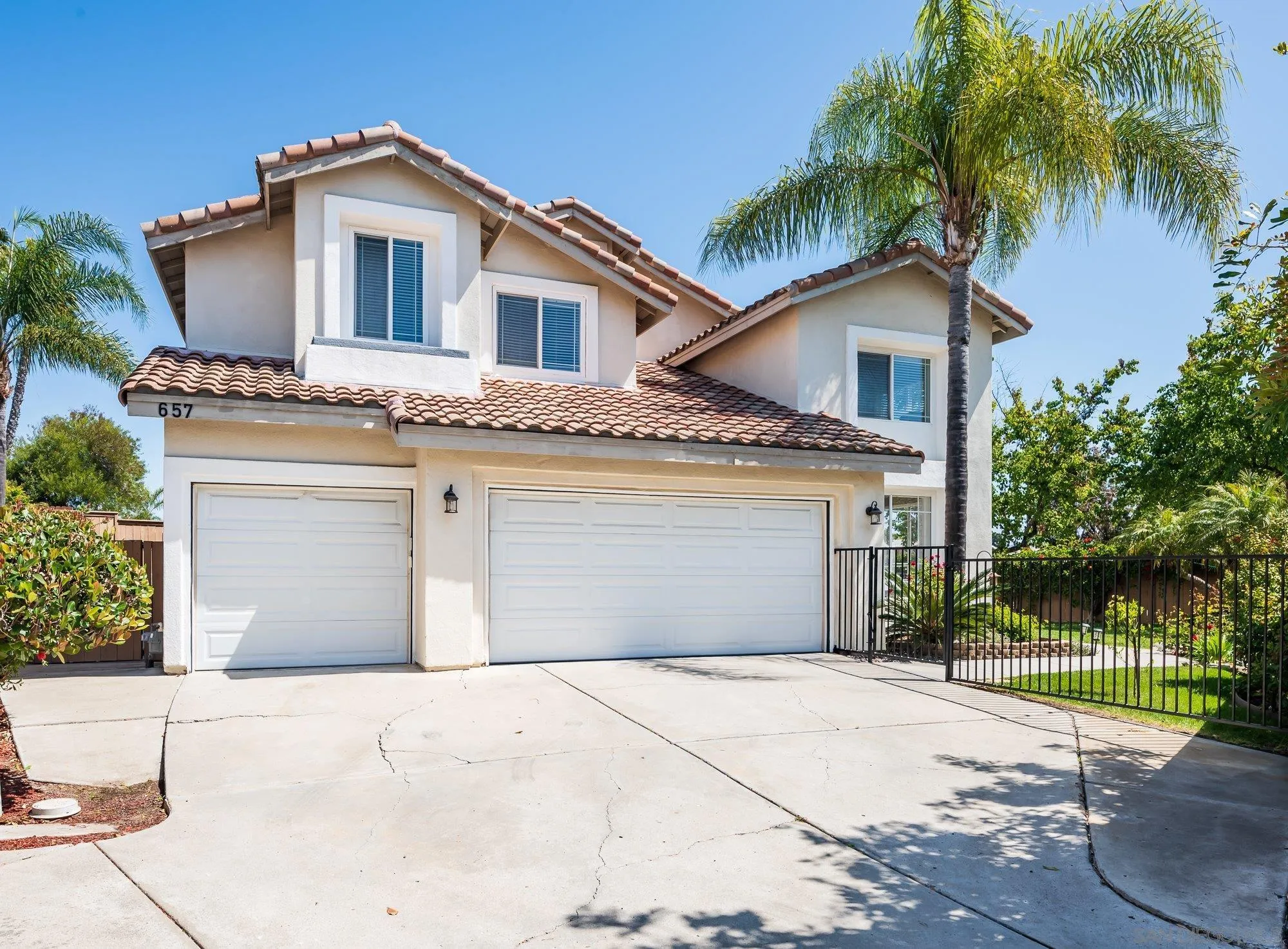 657 Cantara Lane Vista, CA 92081 - Photo 2 of 61 a front view of a house with a yard and garage