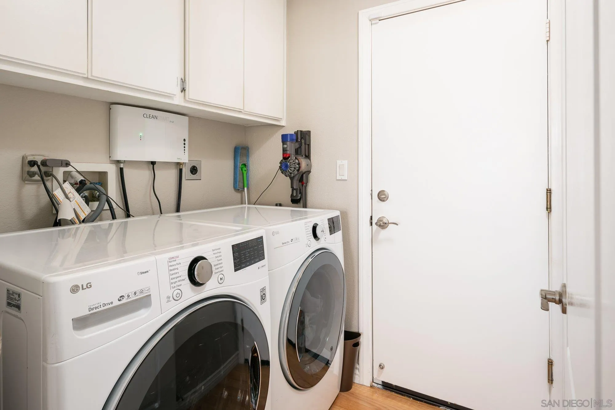 657 Cantara Lane Vista, CA 92081 - Photo 39 of 61 a view of washer and dryer with kitchen in the background