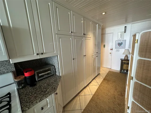 a kitchen with granite countertop white cabinets and white appliances