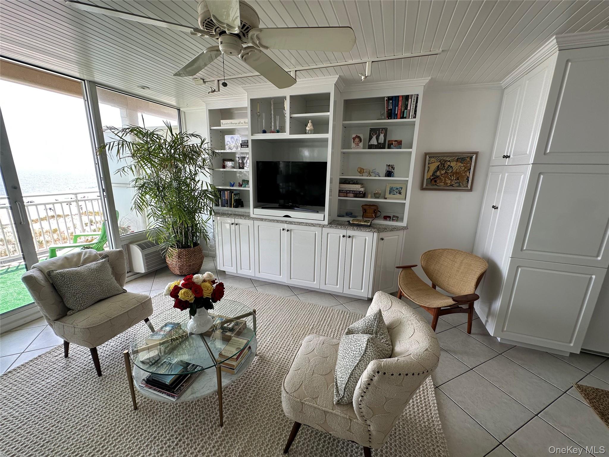 830 Shore Road, Unit 5T Long Beach, NY 11561 - Photo 7 of 18 a living room with furniture a flat screen tv and a large window