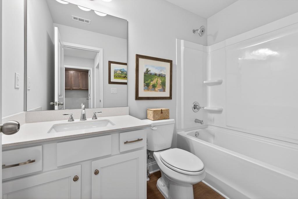 2789 Apperson Way Suwanee, GA 30024 - Photo 17 of 37 a bathroom with a granite countertop toilet sink and mirror