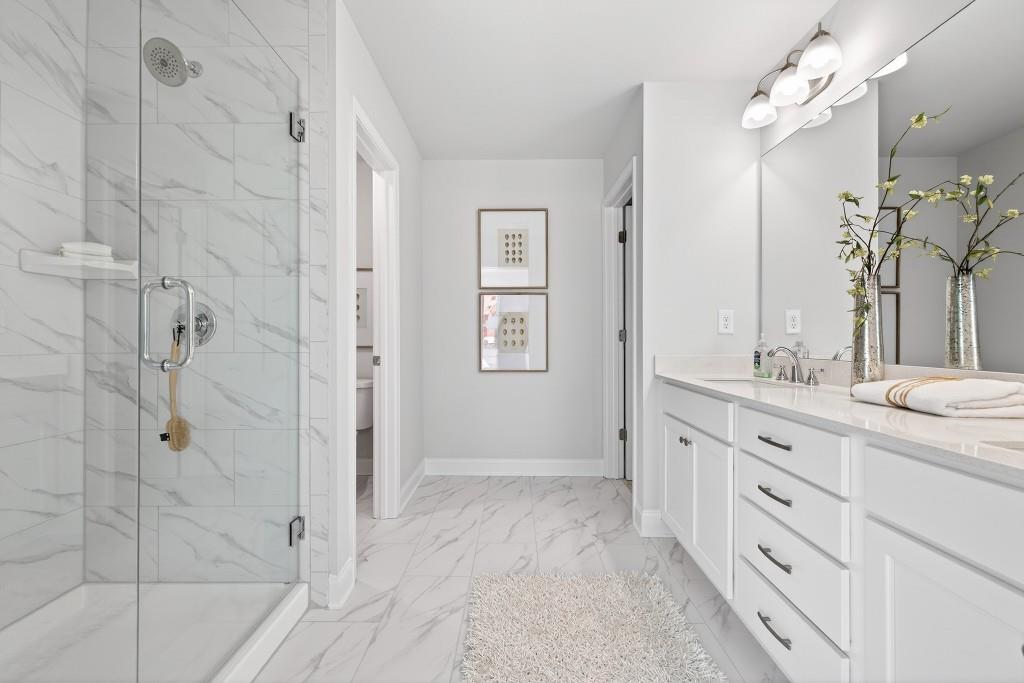 2789 Apperson Way Suwanee, GA 30024 - Photo 21 of 37 a spacious bathroom with a granite countertop sink a mirror and shower
