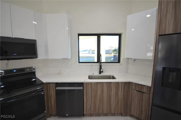 a kitchen with stainless steel appliances granite countertop a refrigerator and a sink
