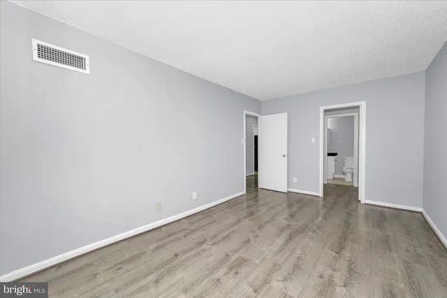 a view of an empty room with wooden floor
