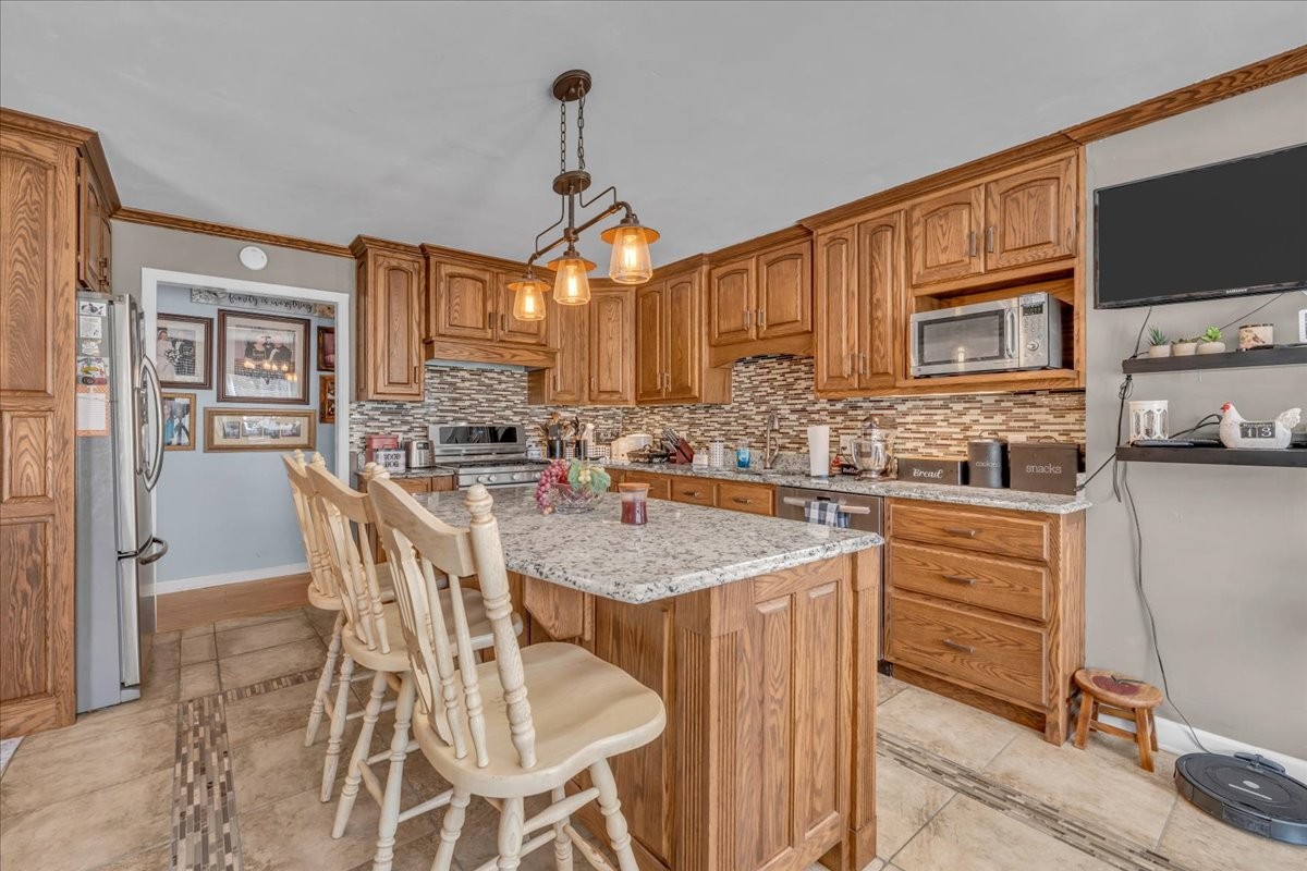 3404 Awalt Road Tullahoma, TN 37388 - Photo 29 of 84 a kitchen with stainless steel appliances granite countertop a sink a stove a dining table and chairs