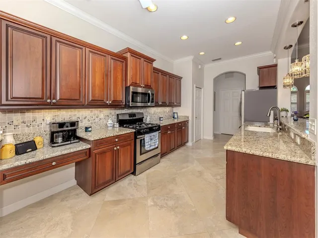 a large kitchen with stainless steel appliances granite countertop a stove a sink dishwasher and cabinets with wooden floor