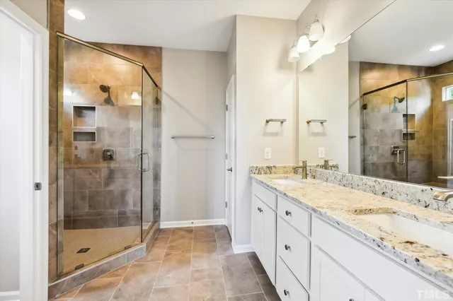 a bathroom with a granite countertop sink mirror and shower
